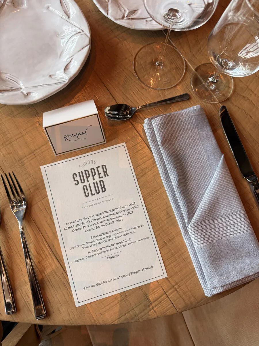 Place setting on a wooden table with a menu titled 
